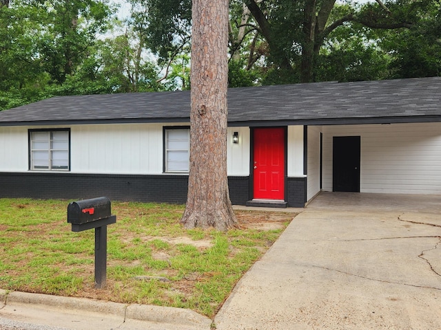 view of front of property with a carport and a front lawn