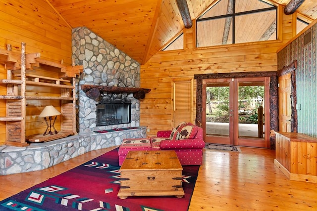 194 Woodsedge Dr, Brookeland, TX 75931 - living room featuring wood finished floors, wood walls, a stone fireplace, wooden ceiling, and high vaulted ceiling