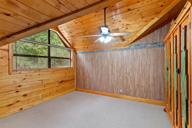 spare room with ceiling fan, wooden ceiling, light colored carpet, vaulted ceiling, and wooden walls