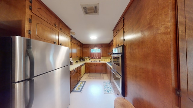 kitchen with stainless steel fridge, sink, white dishwasher, and wooden walls