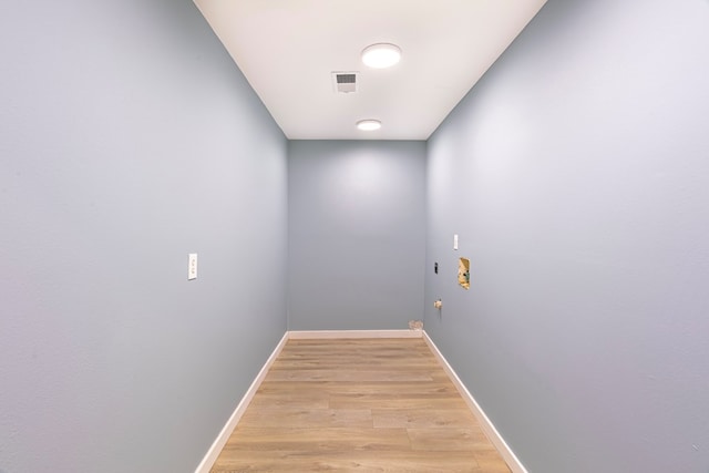 hallway with light wood-type flooring and baseboards