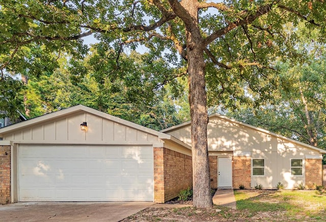 view of front of property with brick siding, board and batten siding, driveway, and an attached garage