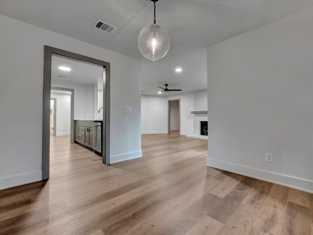 unfurnished living room with built in shelves and light hardwood / wood-style flooring