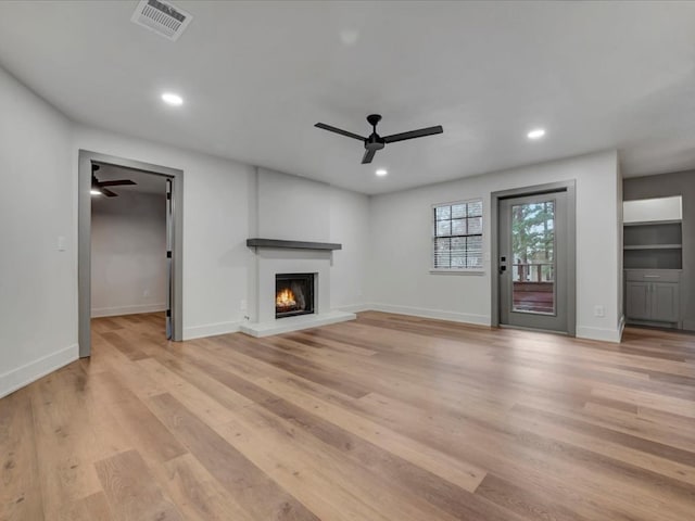 unfurnished living room featuring ceiling fan and light hardwood / wood-style floors