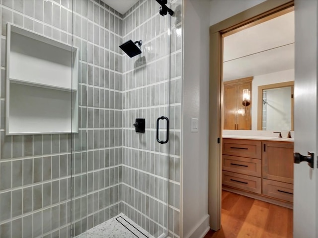 bathroom featuring hardwood / wood-style floors, vanity, and an enclosed shower