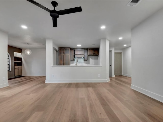 unfurnished living room with light wood-type flooring and sink