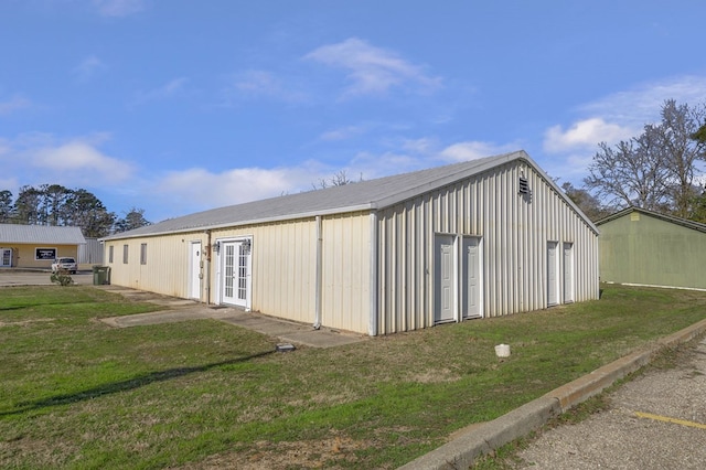 view of outbuilding with a lawn and french doors