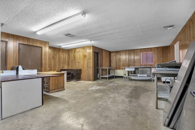 interior space featuring wooden walls and a textured ceiling