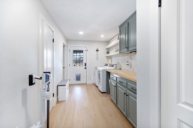 kitchen featuring stainless steel appliances, a wealth of natural light, light hardwood / wood-style floors, white cabinets, and custom exhaust hood