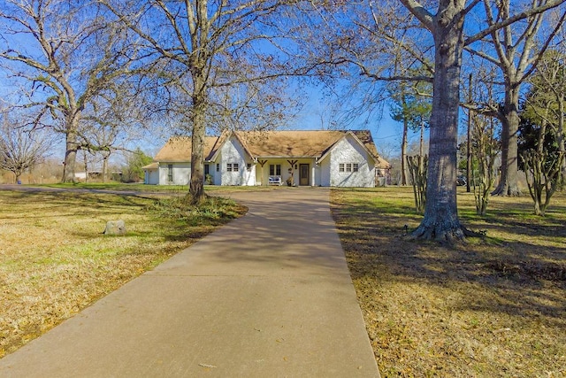 ranch-style home featuring a front lawn