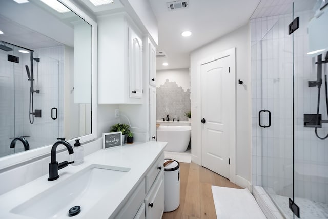 bathroom with vanity, wood-type flooring, and separate shower and tub