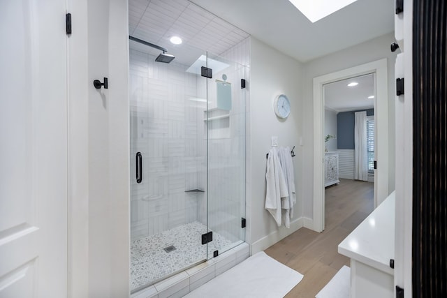 bathroom featuring hardwood / wood-style floors and a shower with shower door