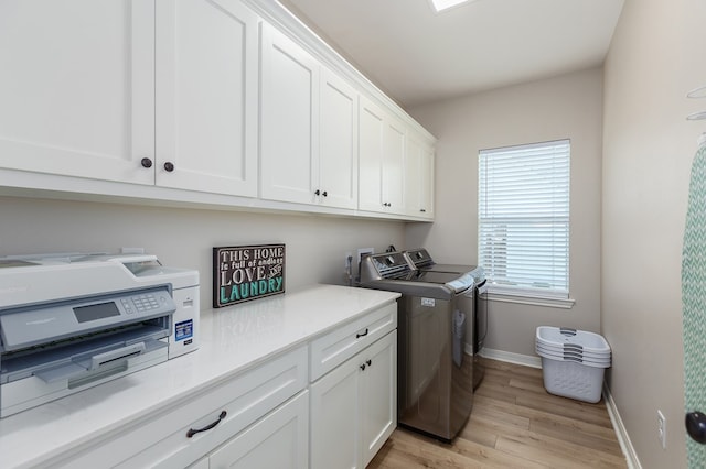 181 Rustic Pines Dr, Lufkin, TX 75904 - laundry area with washer and clothes dryer, cabinet space, light wood-style flooring, and baseboards