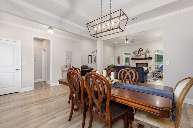 181 Rustic Pines Dr, Lufkin, TX 75904 - dining space featuring light wood finished floors, baseboards, a fireplace, crown molding, and a ceiling fan