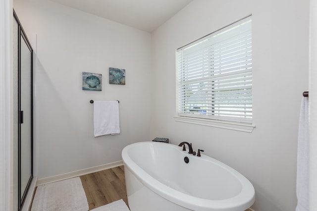 181 Rustic Pines Dr, Lufkin, TX 75904 - bathroom featuring wood finished floors, a freestanding bath, a shower stall, and baseboards