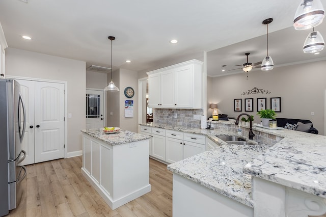 181 Rustic Pines Dr, Lufkin, TX 75904 - kitchen featuring freestanding refrigerator, a sink, ceiling fan, decorative backsplash, and light wood-style floors