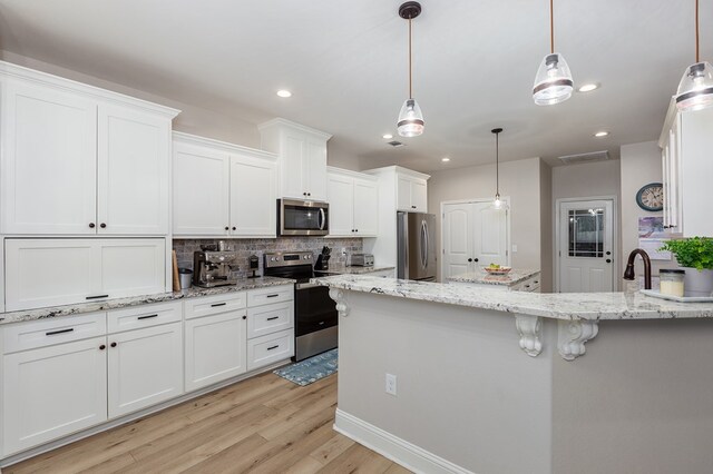 181 Rustic Pines Dr, Lufkin, TX 75904 - kitchen with appliances with stainless steel finishes, tasteful backsplash, light wood-type flooring, white cabinets, and light stone counters