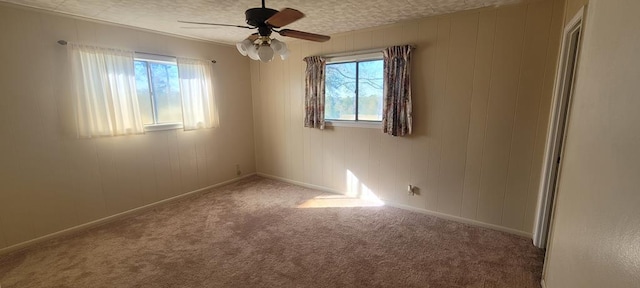 carpeted spare room with a textured ceiling and ceiling fan