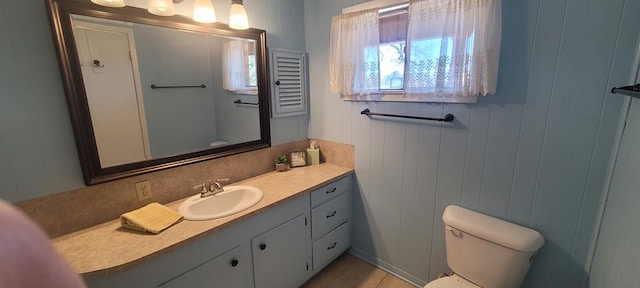 bathroom featuring tile patterned floors, vanity, and toilet