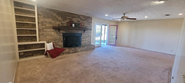 unfurnished living room with carpet flooring, ceiling fan, french doors, built in features, and a textured ceiling