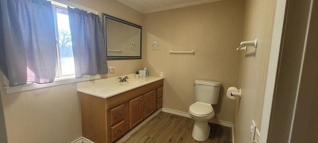 bathroom with hardwood / wood-style flooring, vanity, toilet, and ornamental molding