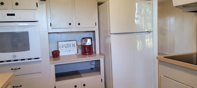 kitchen featuring decorative backsplash and white appliances