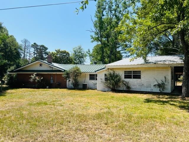 rear view of property with a lawn