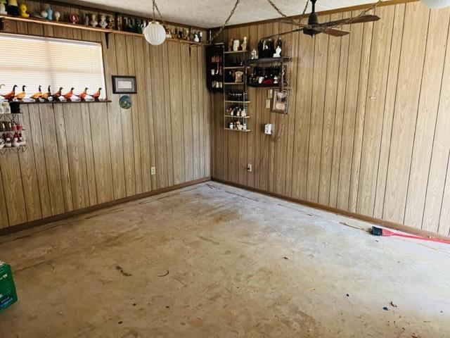 2090 Worth St, Hemphill, TX 75948 - unfurnished dining area with wood walls and ceiling fan