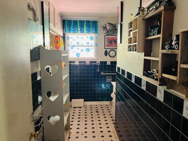 bathroom with tile patterned flooring and tile walls