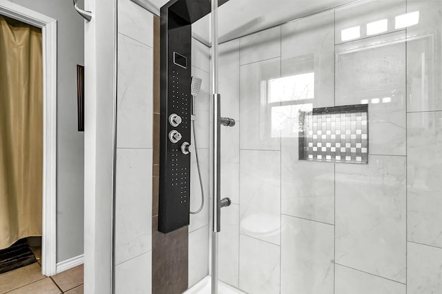 full bathroom featuring tile patterned flooring and a shower stall