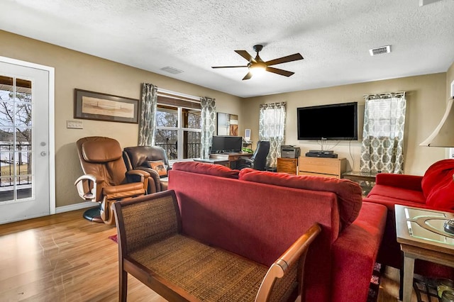 living area featuring a wealth of natural light, wood finished floors, and visible vents