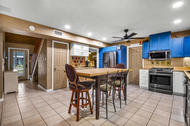 dining area featuring light tile patterned floors, stairs, visible vents, and a ceiling fan