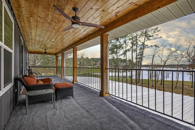 sunroom / solarium featuring ceiling fan, a water view, and wooden ceiling