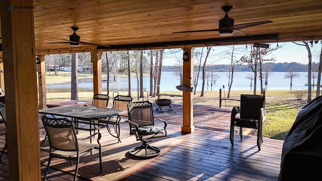deck with a water view and ceiling fan