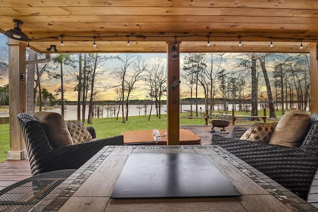 view of patio featuring a water view and fence