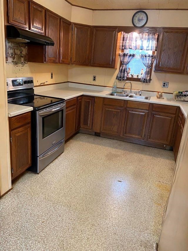 kitchen featuring electric stove, sink, and dark brown cabinets