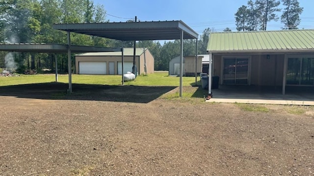 view of vehicle parking with a carport, a garage, and a yard