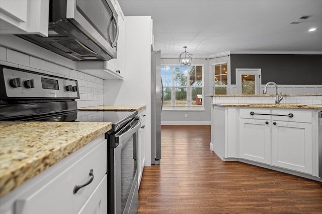 kitchen featuring visible vents, ornamental molding, a sink, dark wood finished floors, and appliances with stainless steel finishes