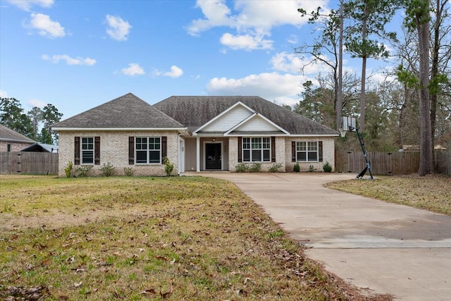 ranch-style house with brick siding, roof with shingles, a front yard, and fence