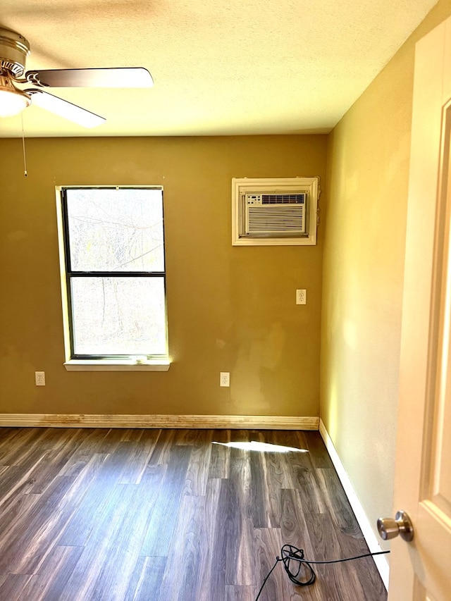 spare room with ceiling fan, a wall mounted AC, and dark hardwood / wood-style floors