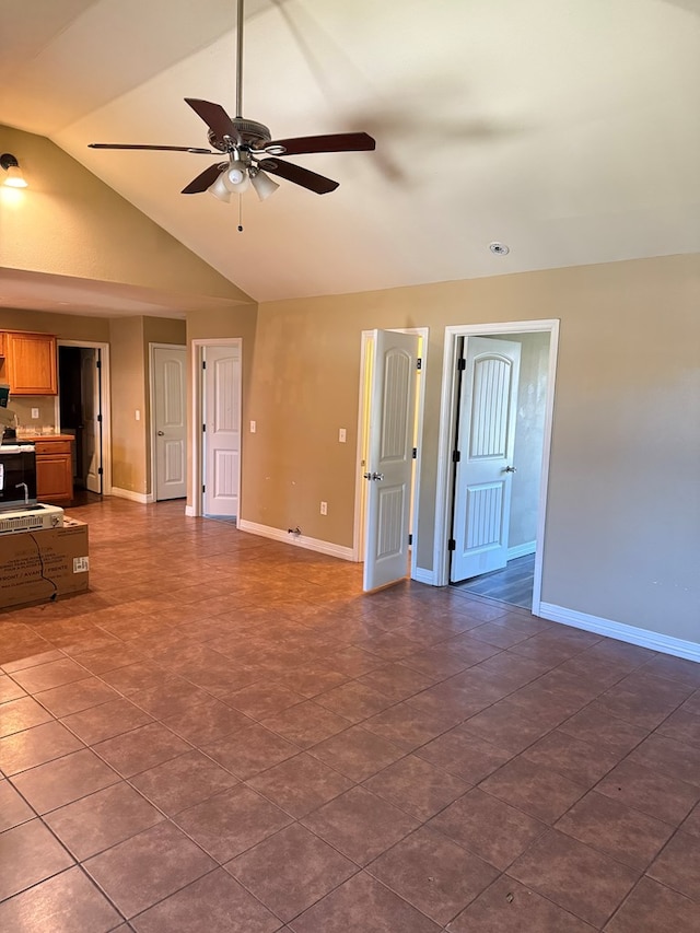 interior space with vaulted ceiling, ceiling fan, and dark tile patterned floors