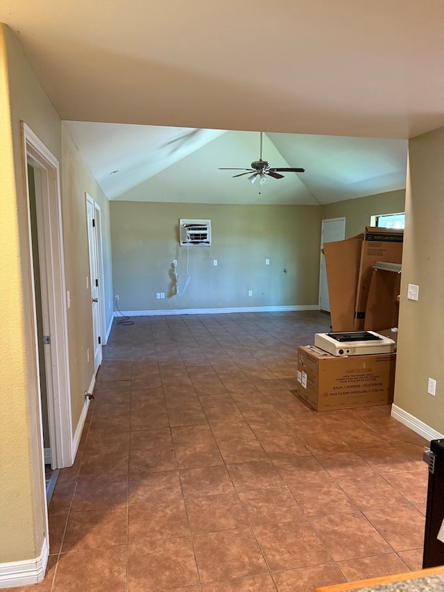 unfurnished living room featuring vaulted ceiling, ceiling fan, tile patterned floors, and a wall unit AC