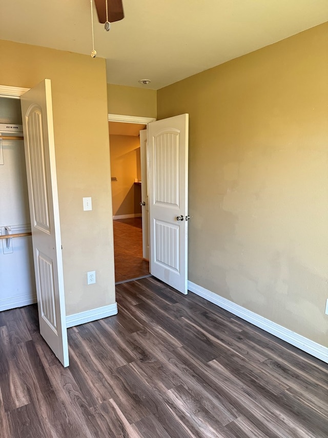 unfurnished bedroom featuring a closet, dark hardwood / wood-style flooring, and ceiling fan