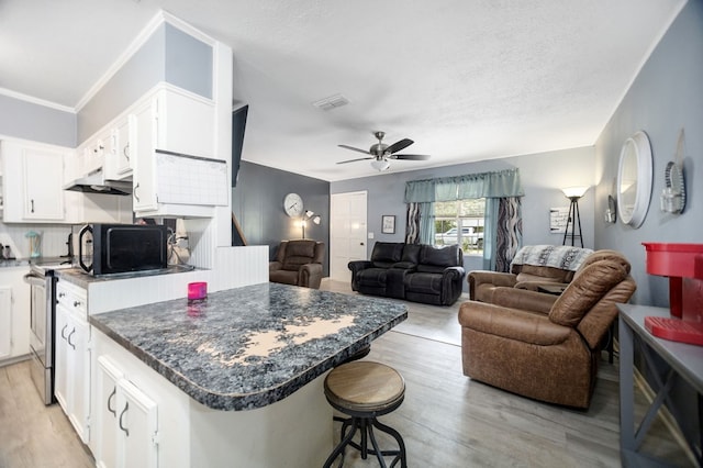 277 Mcclendon Rd, Lufkin, TX 75904 - kitchen with electric range, black microwave, white cabinets, dark countertops, and a textured ceiling