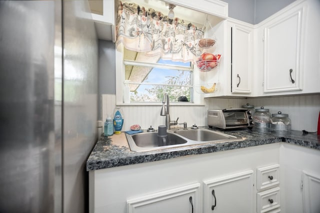 277 Mcclendon Rd, Lufkin, TX 75904 - kitchen with freestanding refrigerator, white cabinets, and dark countertops