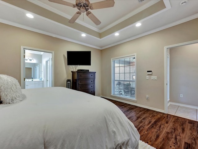 bedroom featuring ornamental molding, a tray ceiling, ceiling fan, connected bathroom, and dark hardwood / wood-style floors