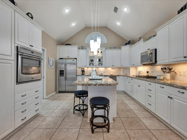 kitchen featuring light stone countertops, stainless steel appliances, and white cabinets