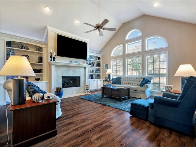 living room featuring dark hardwood / wood-style floors, ceiling fan, a tile fireplace, and built in shelves