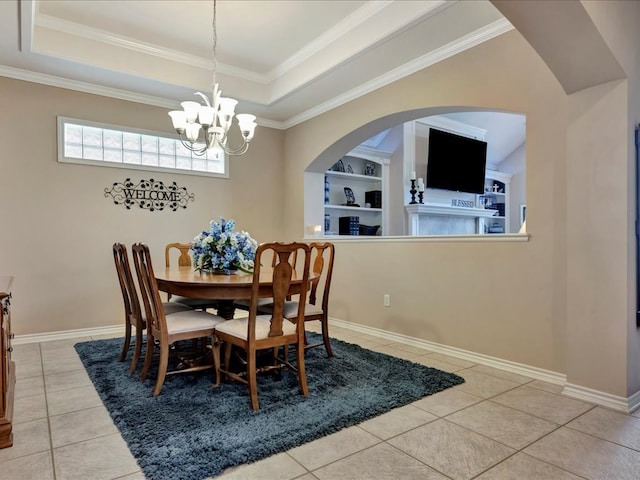 tiled dining room featuring a raised ceiling, built in shelves, crown molding, and a notable chandelier