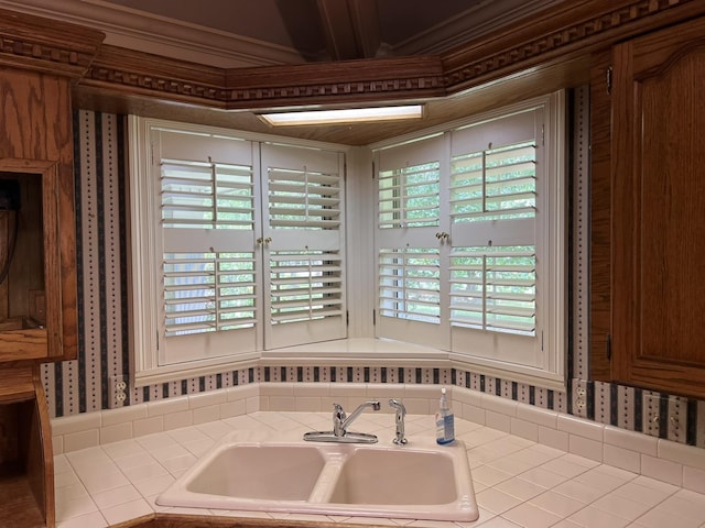 bathroom featuring a washtub, ornamental molding, and sink